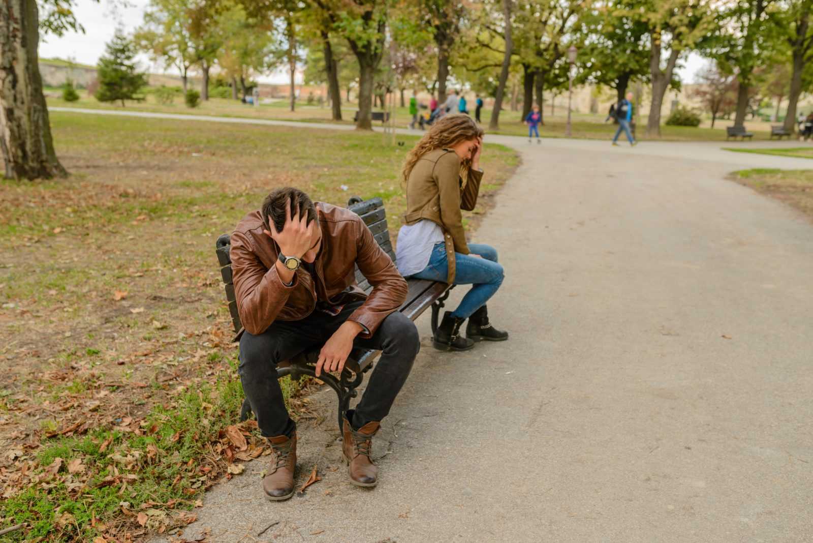 man and woman sitting on bench